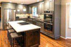 a large kitchen with stainless steel appliances and wood flooring is pictured in this image