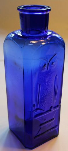 a blue glass vase sitting on top of a table