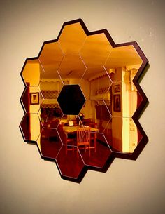 the reflection of a dining room table and chairs in a circular mirror on a wall