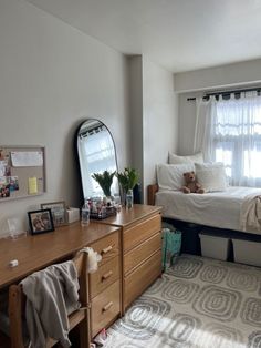 a bedroom with a bed, dresser and mirror in it's centerpieces