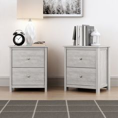 two nightstands with books and an alarm clock on them in front of a white wall