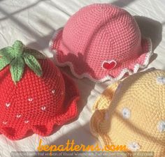 three crocheted strawberries sitting on top of a bed