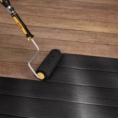 a mop is laying on top of a wooden floor next to a black mat