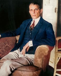 a man in a suit sitting on a chair