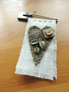 a small piece of fabric with buttons on it sitting on top of a wooden table