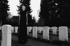 a woman standing in the middle of a cemetery