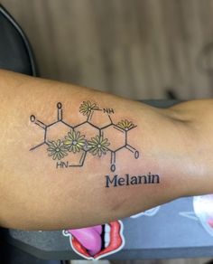 a tattoo with the name melanin written on it's arm and flowers