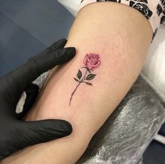 a woman's arm with a rose tattoo on it