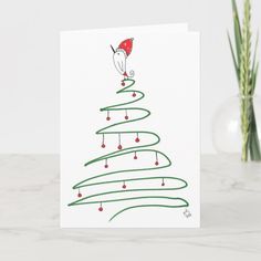 a card with a christmas tree on it and a santa hat hanging from the top