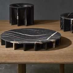 black and white marble table with two stools in the middle, one sitting on top of it