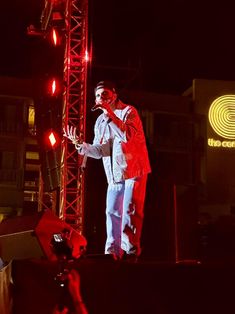 a man standing on top of a stage next to a red light