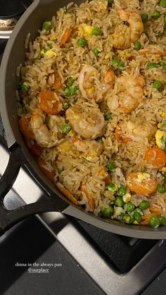 a pan filled with rice and shrimp on top of a stove