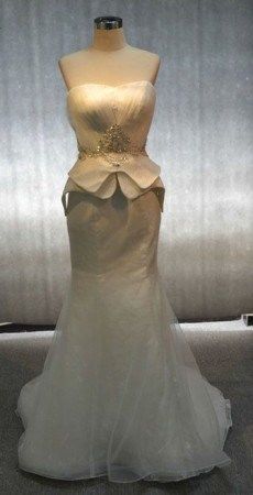 a white wedding dress on display in a room