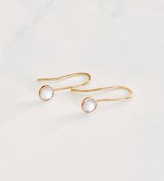 These simple, beautiful earrings are dainty but and versatile enough to be worn everyday.    They feature a 6mm white mother of pearl cabochon set in a 14kt gold filled bezel.  The ear wire is hand forged from 14kt gold filled wire.  The stone dangles about 1/2" below the earlobe. Minimalist White Pearl Earrings In 14k Gold Filled, Minimalist White Pearl Earrings 14k Gold Filled, Minimalist White 14k Gold Filled Pearl Earrings, Minimalist 14k White Gold Earrings, Nickel-free White Pearl Earrings In 14k Gold, Minimalist White Pearl Earrings In 14k Gold, Minimalist 14k Gold Filled Round Pearl Earrings, Minimalist 14k Gold White Pearl Earrings, Dainty White Nickel-free Pearl Earrings