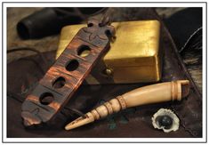 a wooden instrument and some other items on a leather bag with a gold box in the background