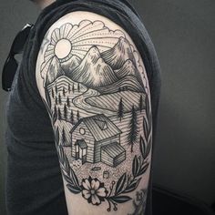 a man with a tattoo on his arm that has mountains and houses in the background