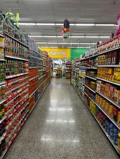 an aisle in a grocery store filled with lots of food and drinks on the shelves