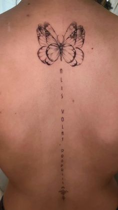 a woman's back with a butterfly tattoo on her lower back and the words love written in cursive writing