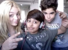 two boys and a girl are posing for the camera with headphones in their ears