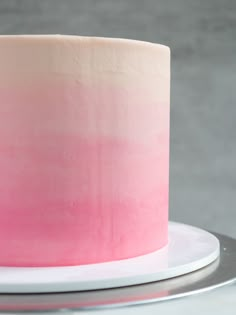 a pink and white ombrella cake on a plate