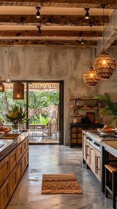 an open kitchen with lots of counter space and lights hanging from the ceiling above it