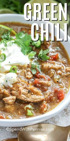 a bowl of green chili with sour cream and cilantro