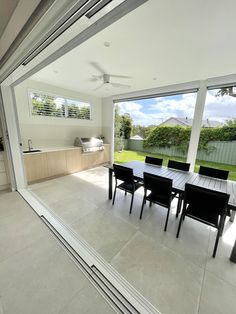 an outdoor dining area with large sliding glass doors leading to the back yard and backyard