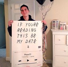 a man holding a sign that says if you're reading this be my date