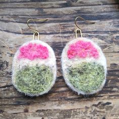 the earrings are decorated with grass and pink flowers