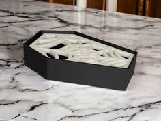 a black and white box sitting on top of a marble counter