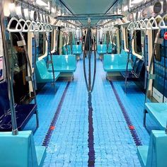 the inside of a subway car with blue seats and tile flooring on both sides