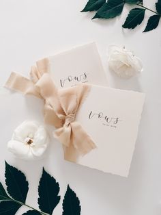 two pieces of paper with the word paris on them next to some leaves and flowers