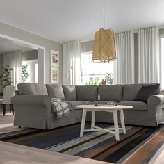 a living room filled with furniture and a rug on top of a hard wood floor