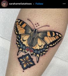 a yellow and black butterfly tattoo on the left leg, with red dots around it