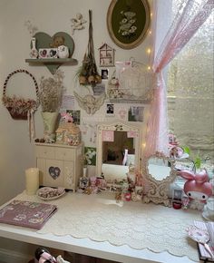 a white desk topped with lots of clutter and decor on it's walls