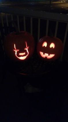 two pumpkins with faces carved into them