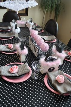 the table is set with pink and black decorations