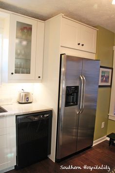 a kitchen with white cabinets and stainless steel appliances