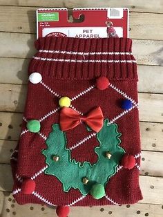 a red christmas stocking with pom poms and a bow tie on it