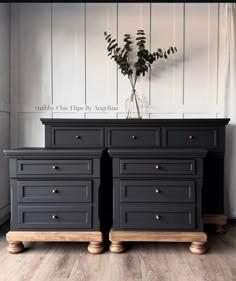 a black dresser with two drawers and a vase on top