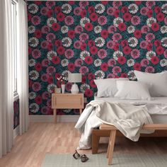 a bed sitting in a bedroom next to a wallpaper covered in red and white flowers