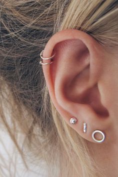 a close up of a person's ear with two piercings on the side