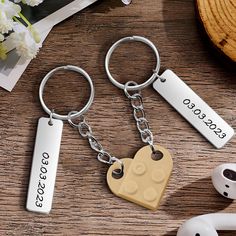 two heart shaped keychains are sitting on a table