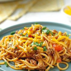 a blue plate topped with spaghetti and meat