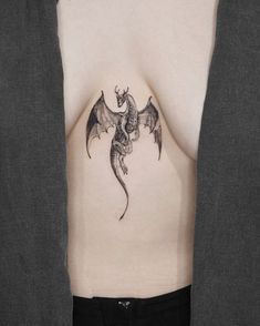 a woman's stomach with a dragon tattoo on her chest and the bottom part of her body