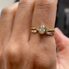 a woman's hand with a gold ring and two diamond rings on top of it