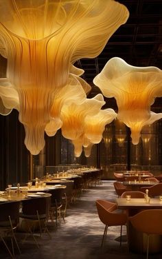 a large dining room filled with lots of tables covered in yellow cloths hanging from the ceiling