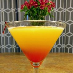 an orange and red drink sitting on top of a table