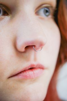 a close up of a person with a nose piercing