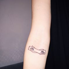 a woman's arm with a tattoo on it that has two hands holding each other